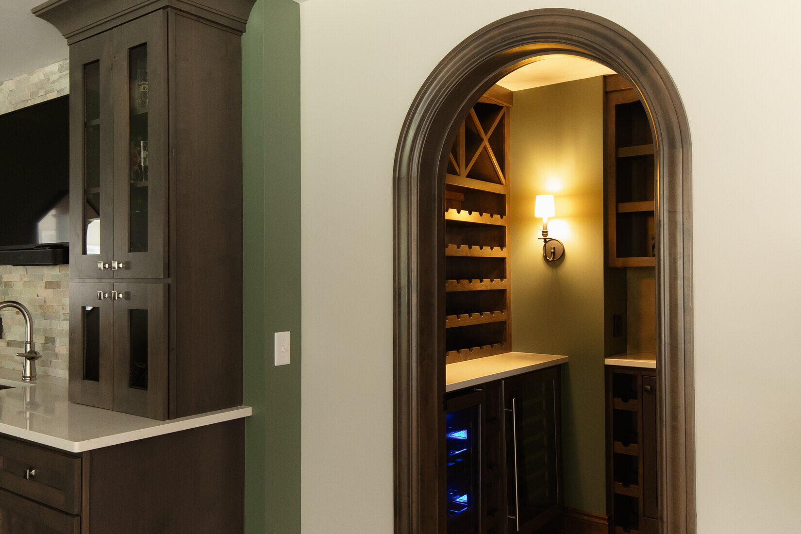 Custom basement wine cellar with arched entry and wood racks by Ridgewood Home Construction in Grand Rapids, MI