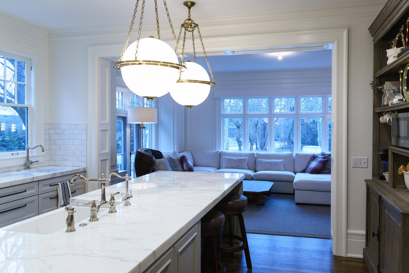 Open kitchen and living space with marble island in West Michigan remodel by Ridgewood Home Construction