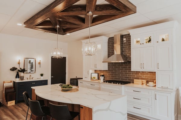 Custom kitchen display at Ridgewood Home Construction’s showroom in Grand Rapids, MI featuring white cabinetry and wood accents
