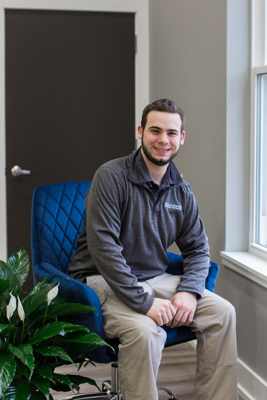 Travis from Ridgewood Home Construction seated by a window in the Grand Rapids, MI showroom