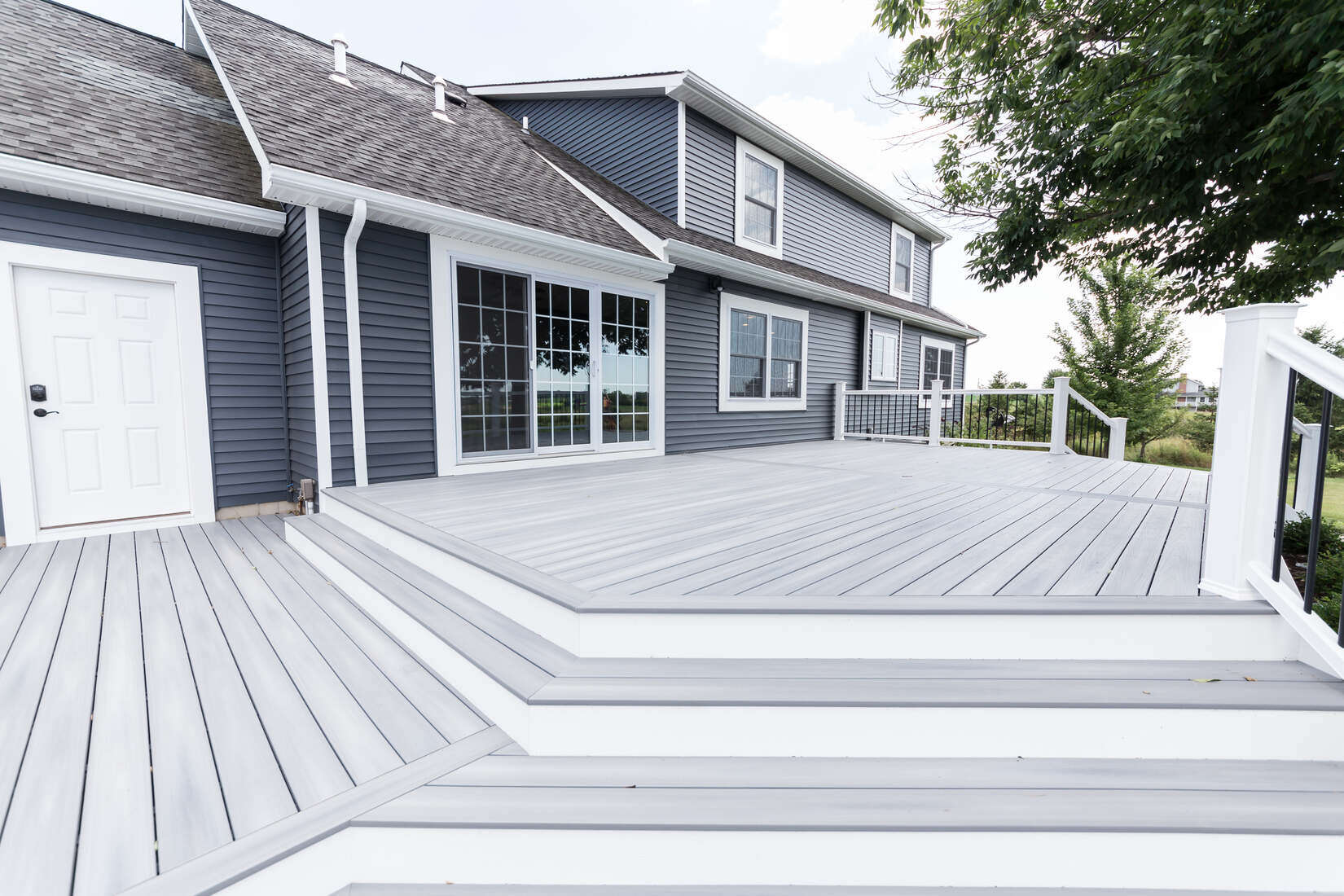 Gray composite deck addition with white trim built by Ridgewood Home Construction in Grand Rapids, MI