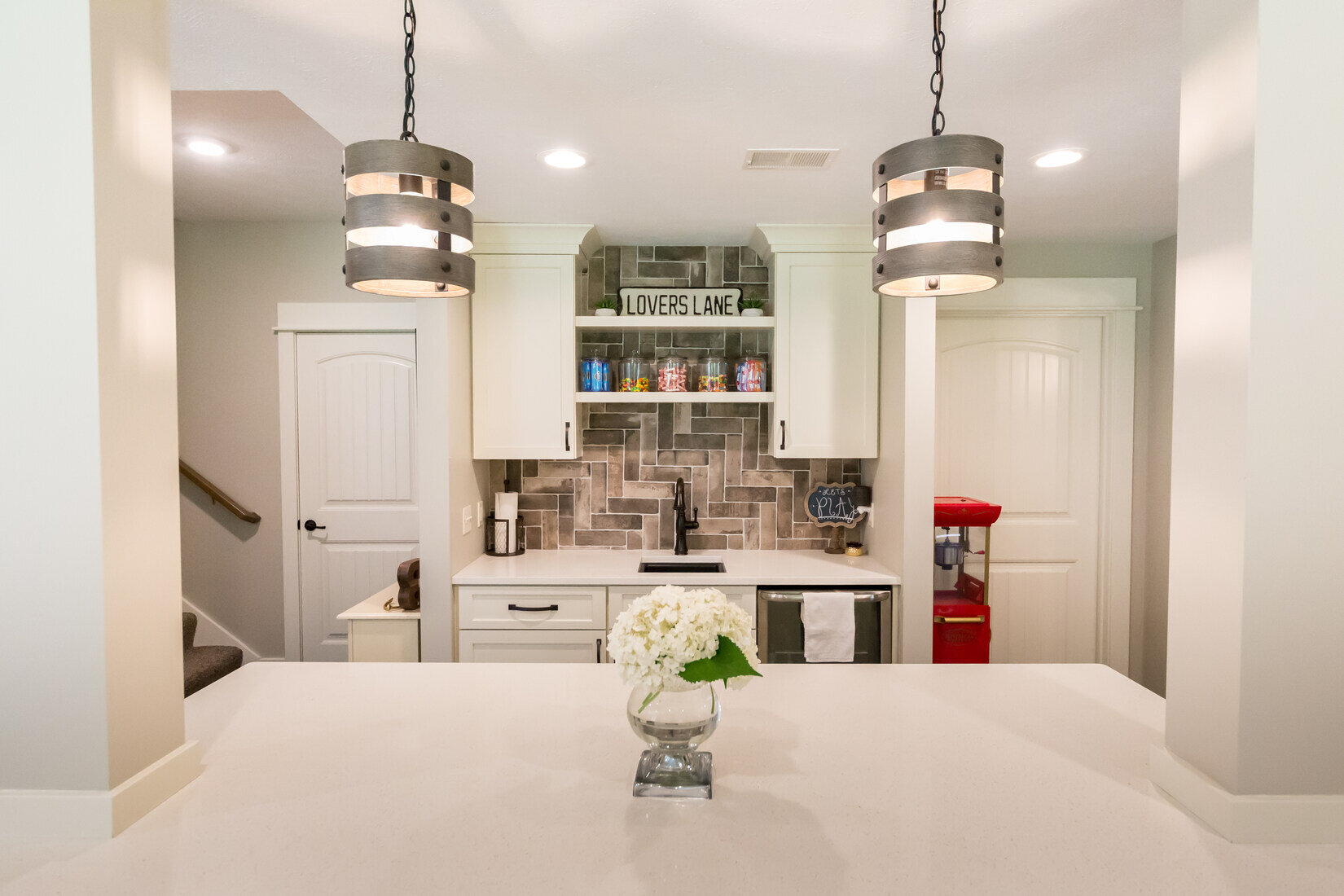 Basement wet bar with pendant lighting and tile backsplash by Ridgewood Home Construction in Grand Rapids, MI