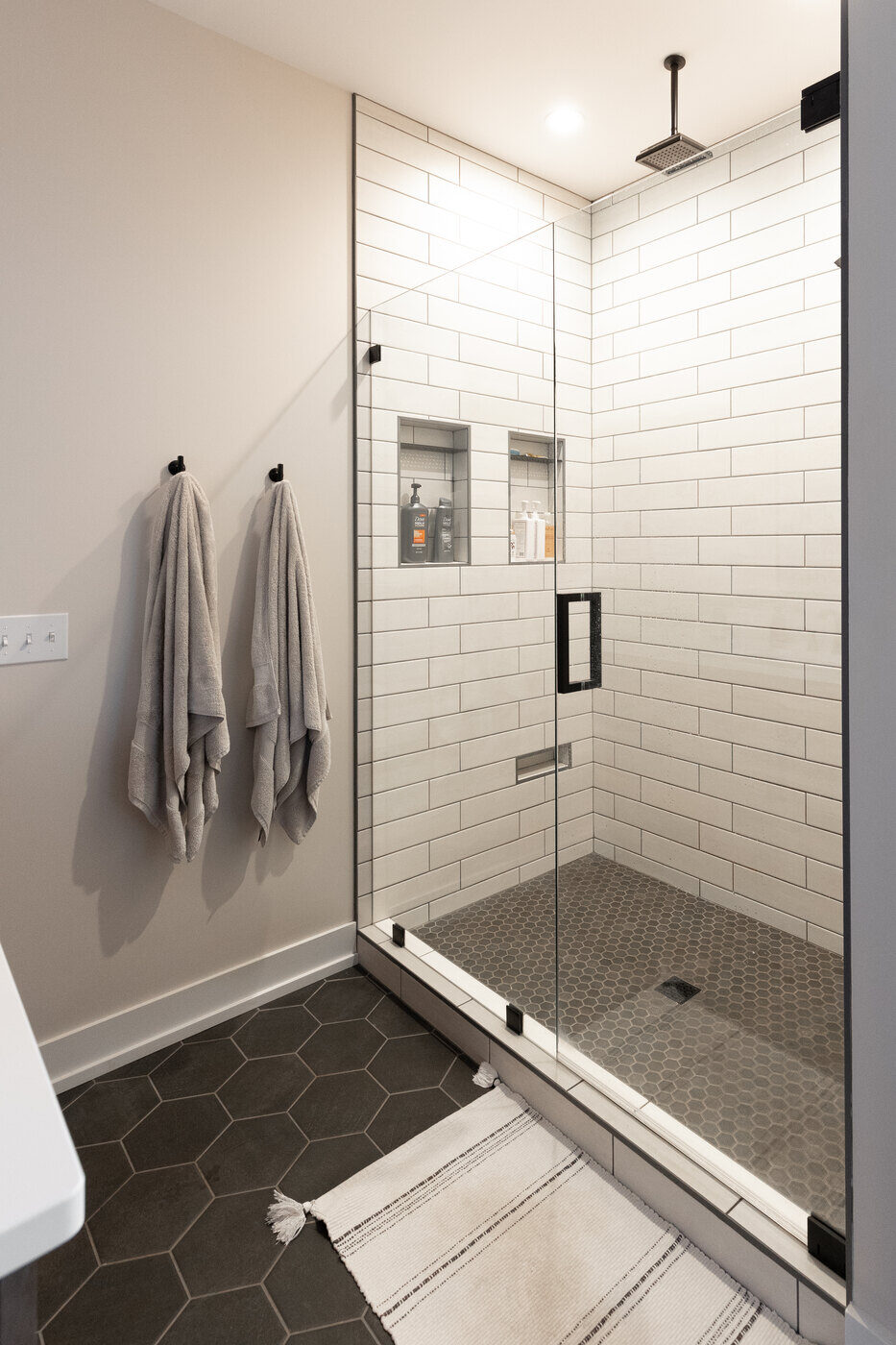 Glass shower with white subway tile and built-in niches in Ridgewood Home Construction’s West Michigan bathroom remodel