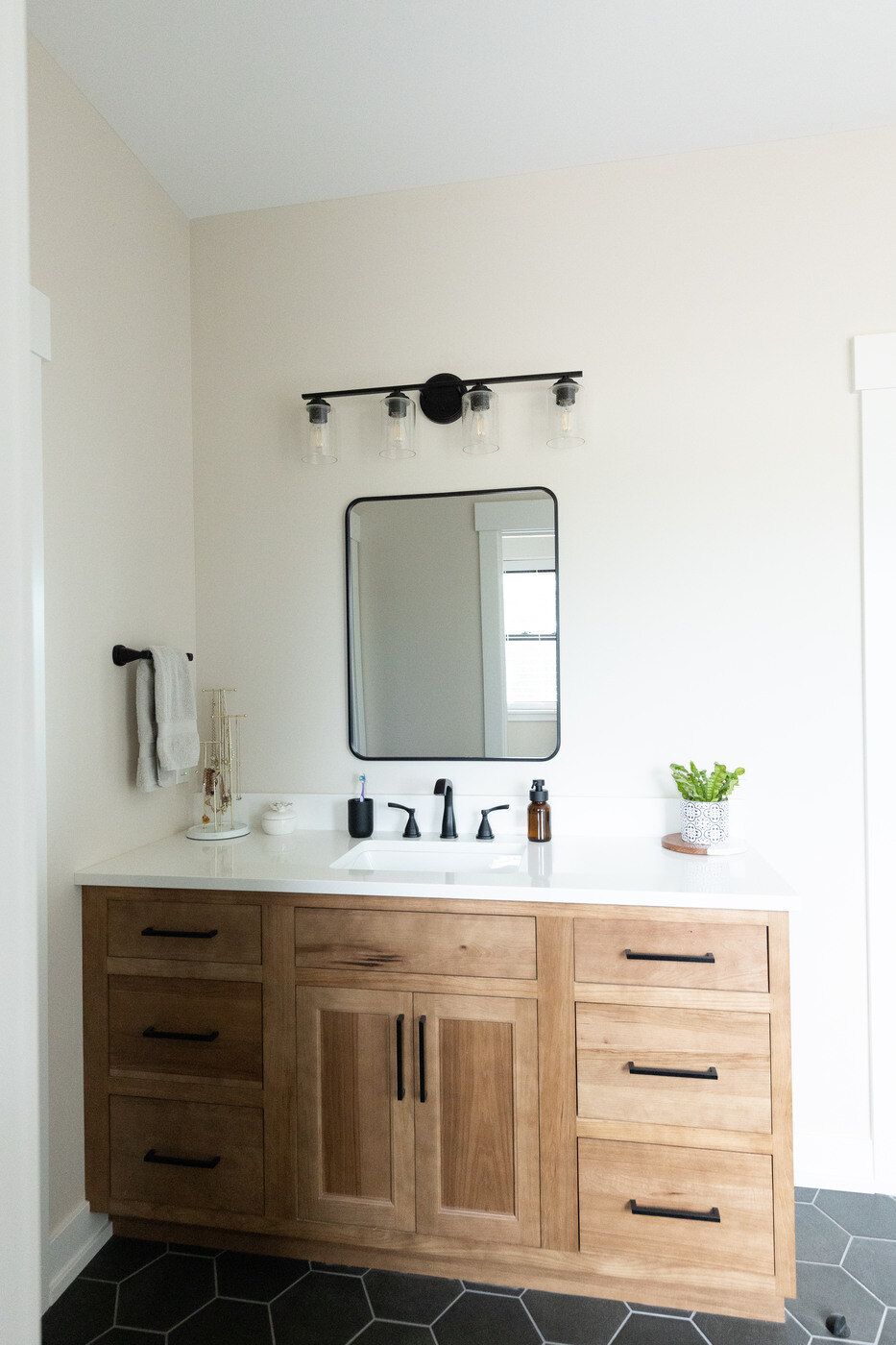 Warm wood vanity with white countertop in a West Michigan bathroom remodel by Ridgewood Home Construction