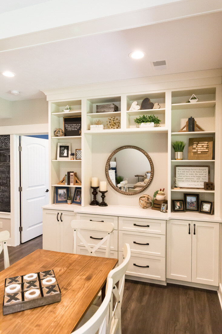 White cabinetry built-in dining nook with round mirror and decor in Grand Rapids remodel by Ridgewood Home Construction