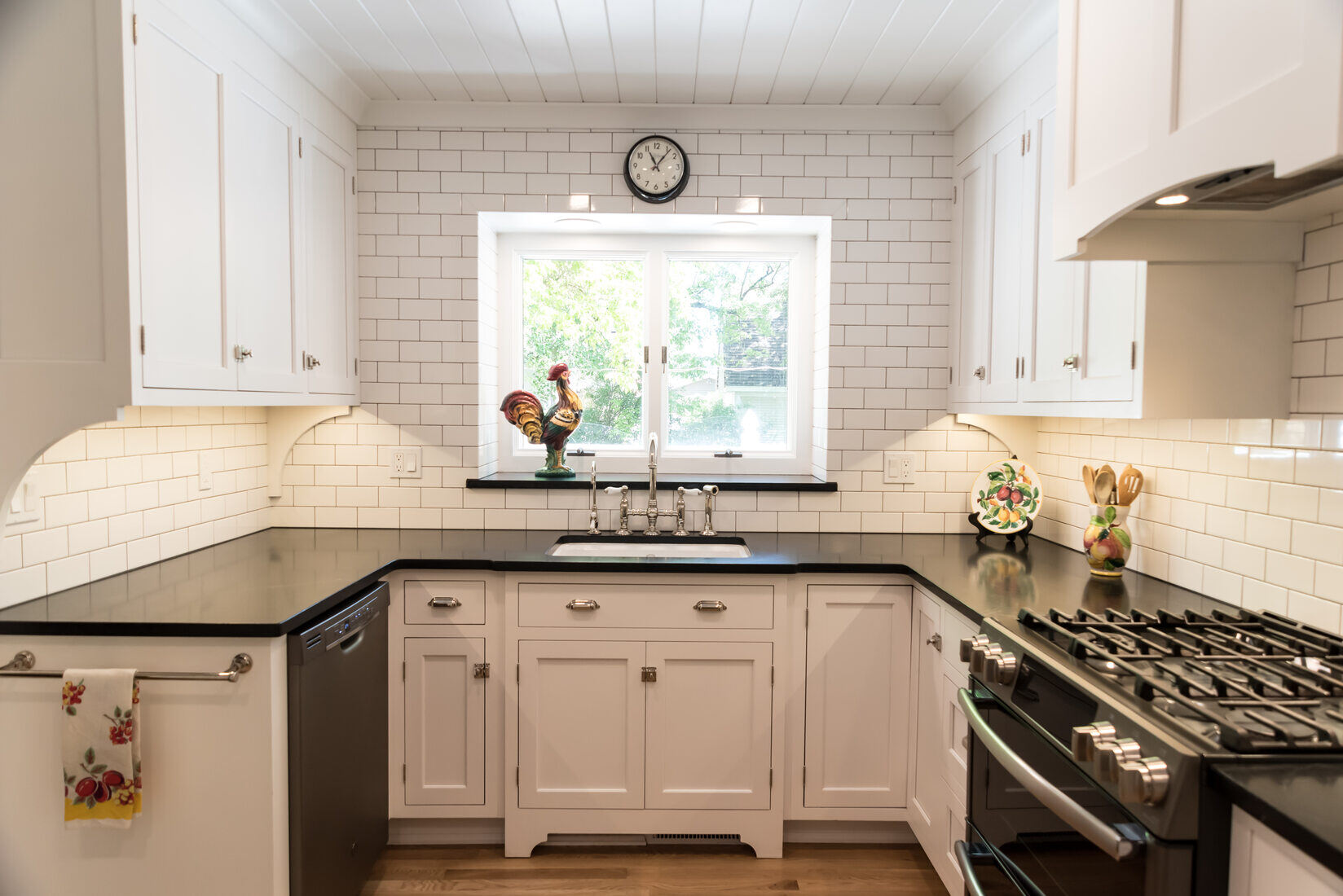 Timeless white kitchen with black countertops and subway tile backsplash in West Michigan by Ridgewood Home Construction