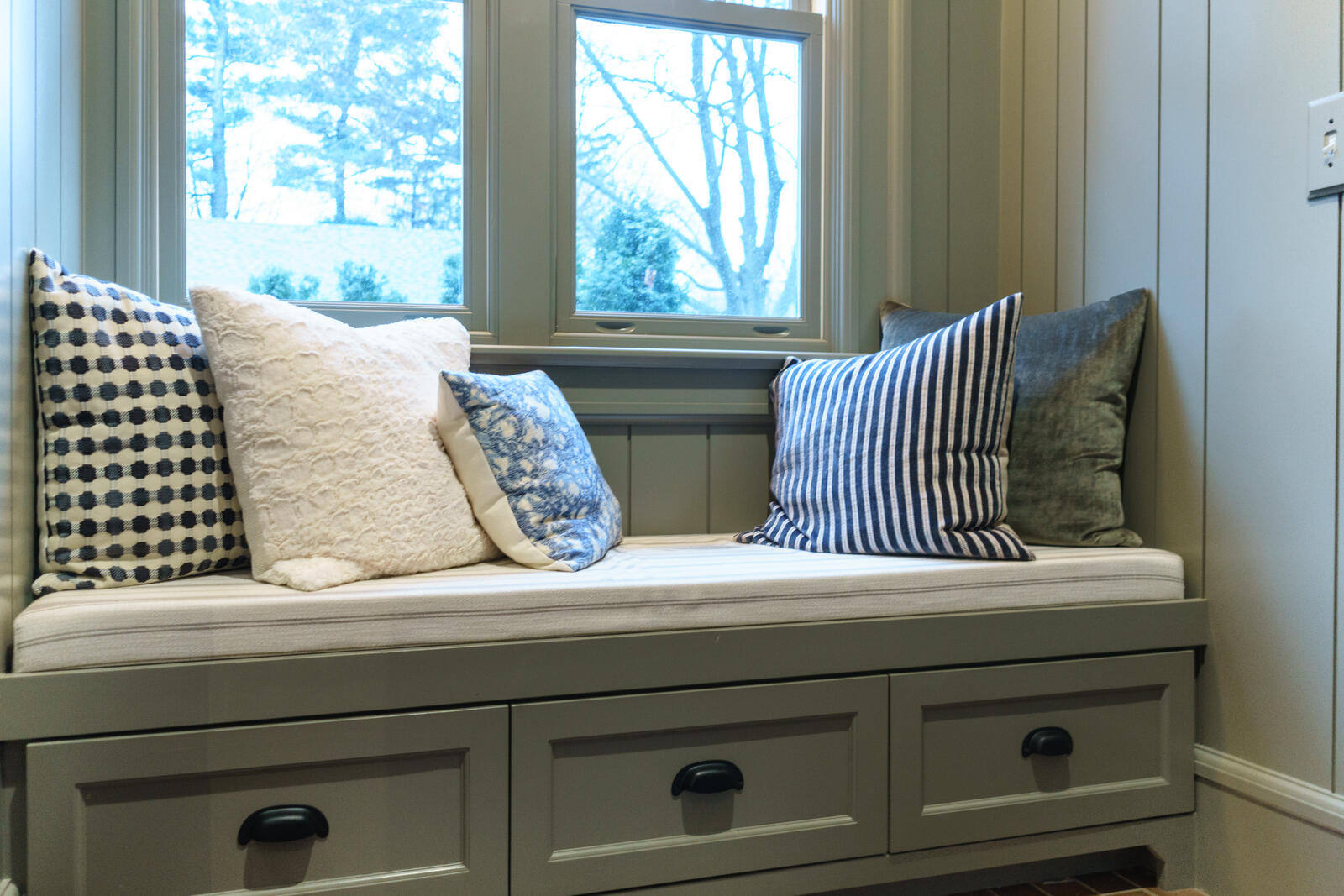Window bench seating in East Grand Rapids mudroom remodel by Ridgewood Home Construction with custom drawers and cushions