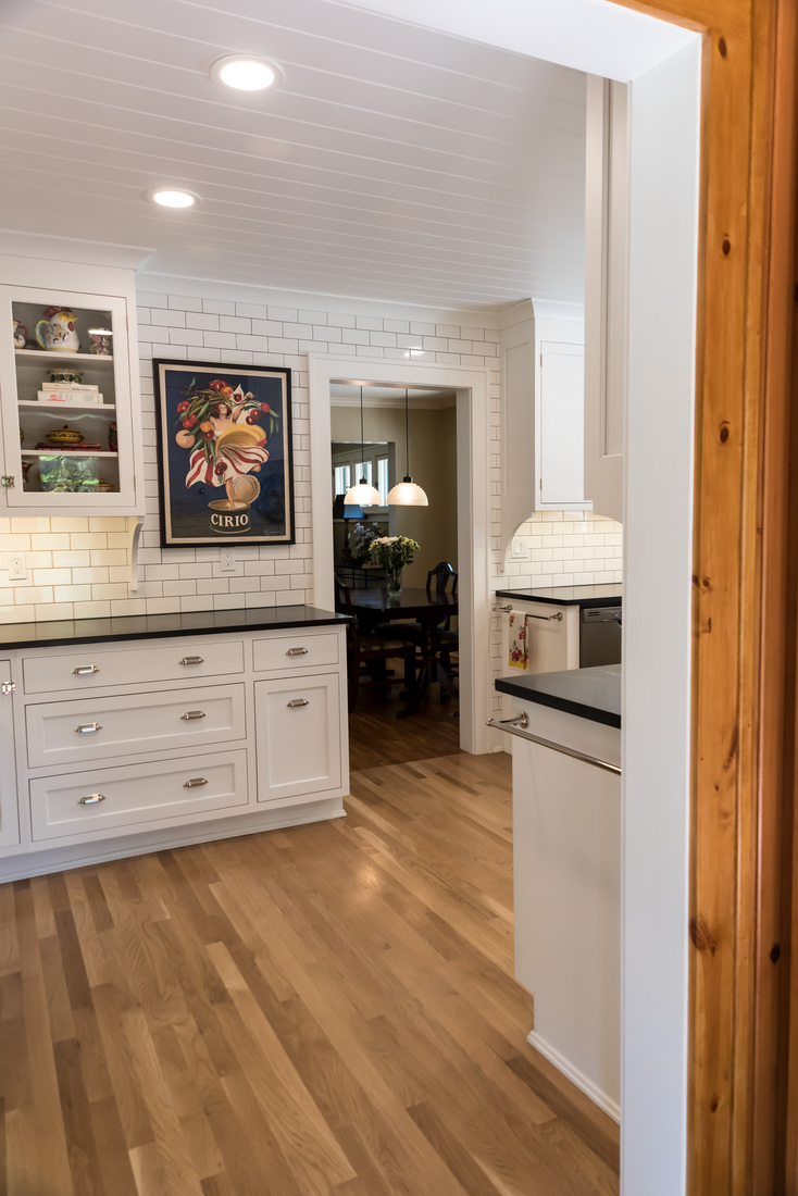 Open view of remodeled kitchen with white cabinets and dining area by Ridgewood Home Construction in Rockford, MI