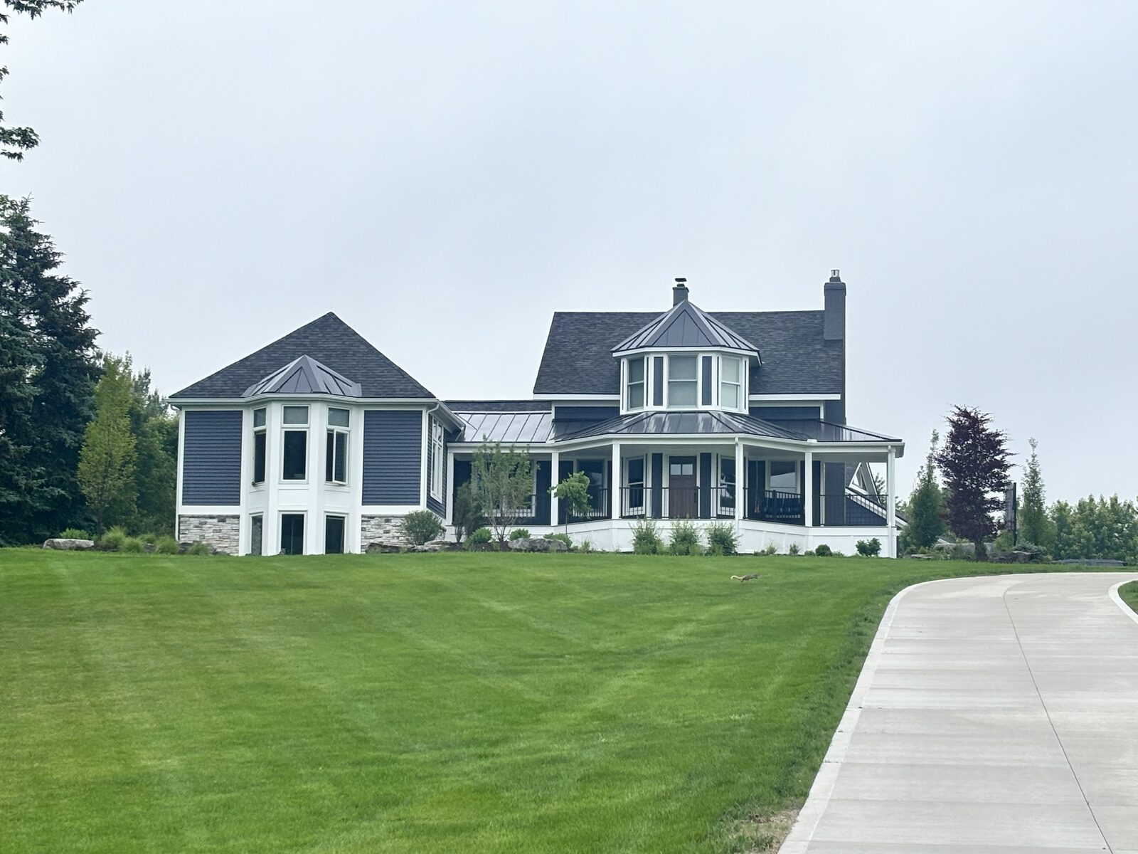 Custom-built Victorian-style home with expansive front lawn by Ridgewood Home Construction in Grand Rapids